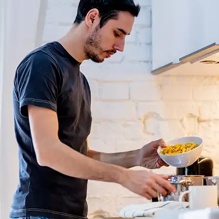 Man cooking in an apartment | Featured image for the NDIS Providers Home Page of Karakan.
